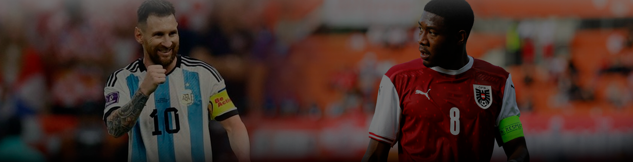 Два футболиста на поле: один в форме сборной Аргентины с капитанской повязкой, другой в форме сборной Австрии, также с повязкой капитана. На заднем плане размытые трибуны стадиона